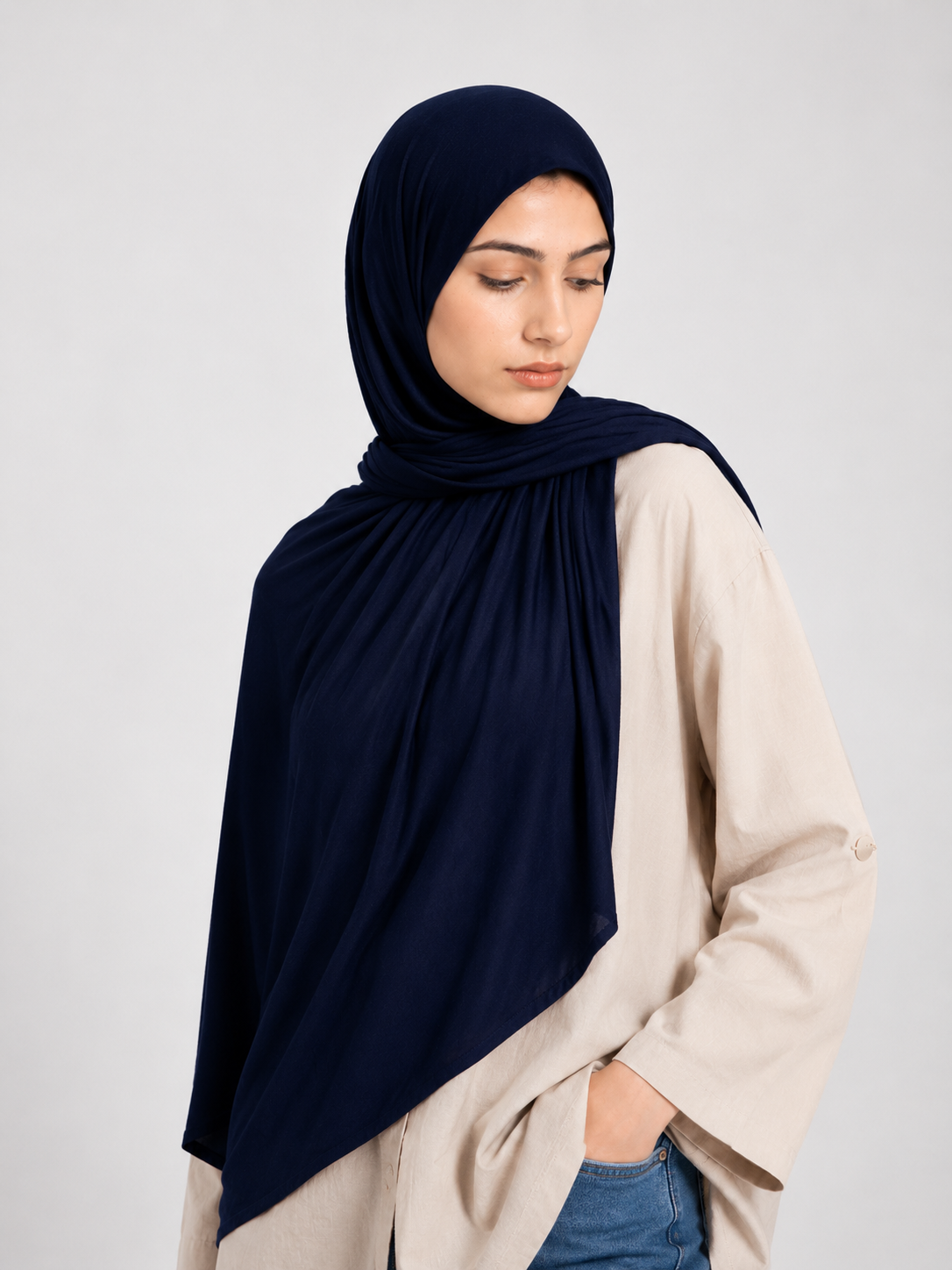 Woman wearing a dark blue navy jersey hijab against a white background
